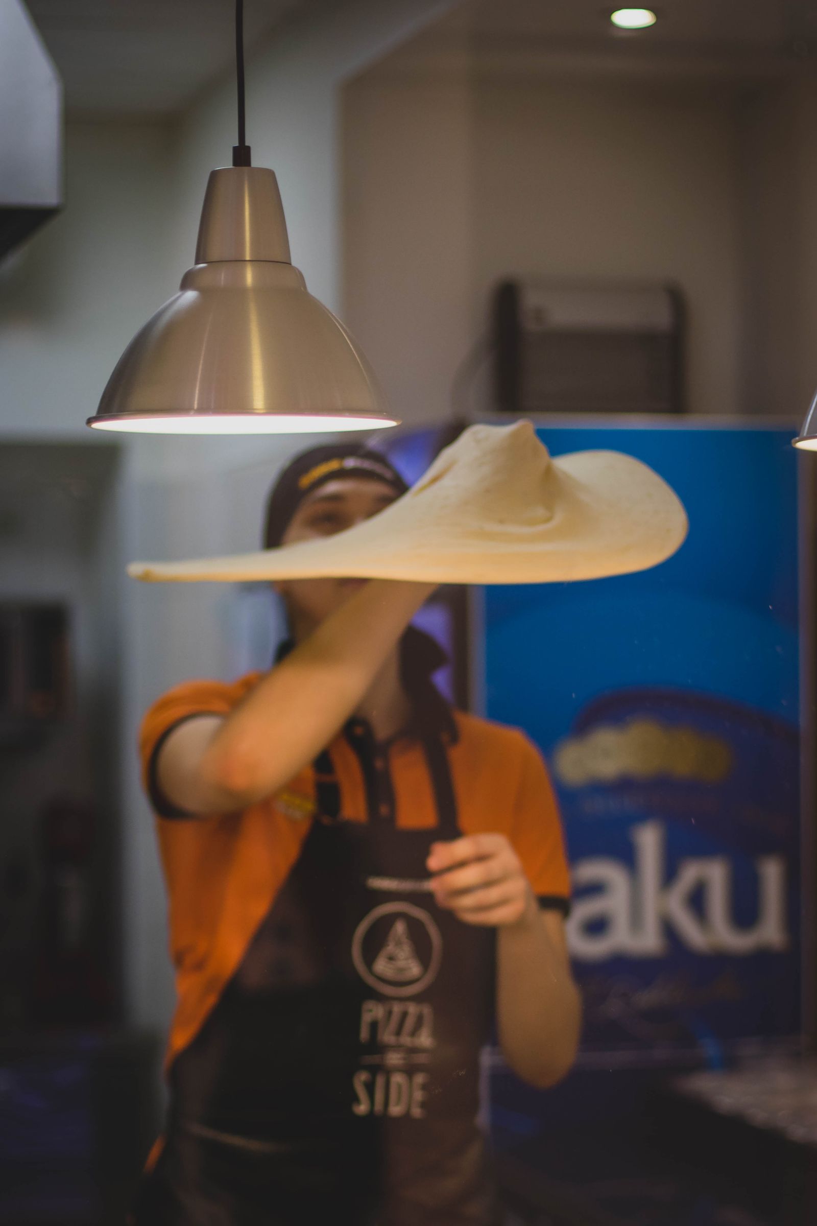 Pembuat pizza membentuk adonan segar
