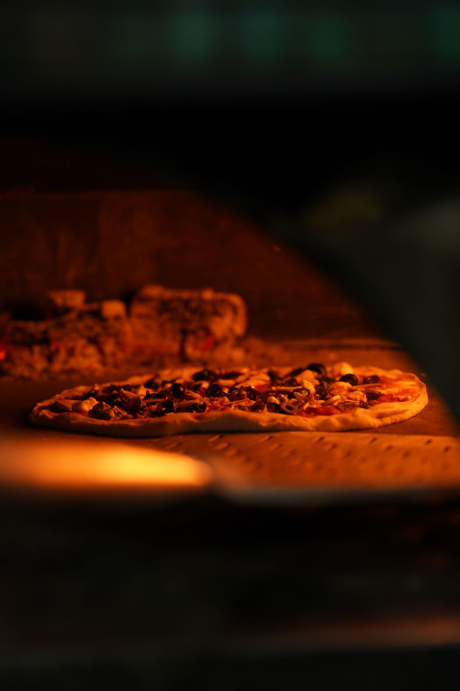 Pizza dipanggang dalam oven kayu